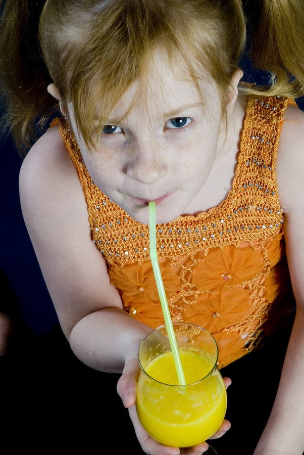 Young girl is drinking orange with a stroh. Young girl is drinking orange with a stroh