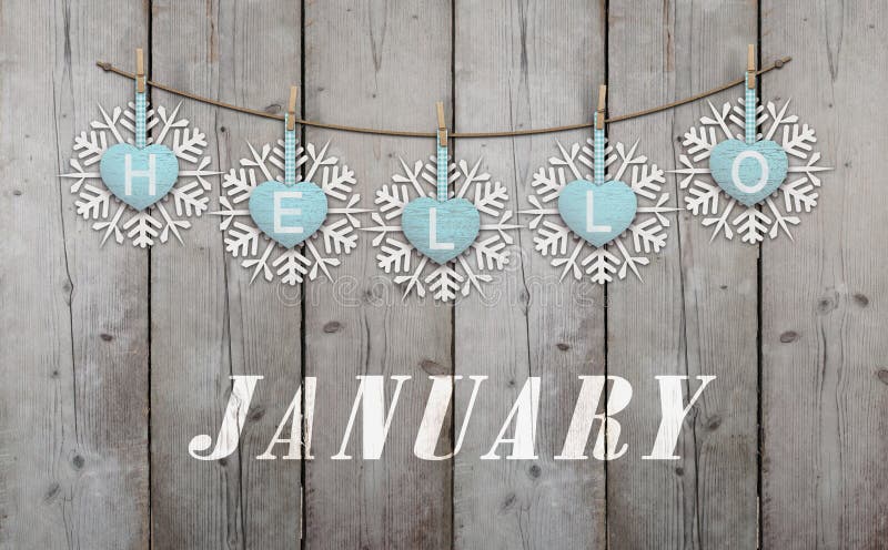 Hello january written on hanging ice blue hearts and white wooden snowflakes on weathered planks background. Hello january written on hanging ice blue hearts and white wooden snowflakes on weathered planks background