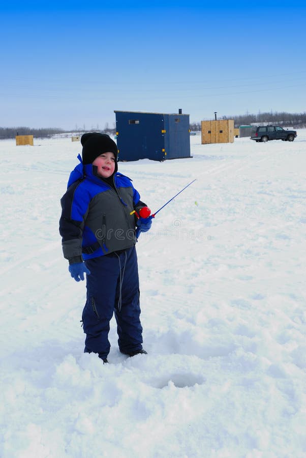 Young boy in blue ice fishing on frozen river. Young boy in blue ice fishing on frozen river