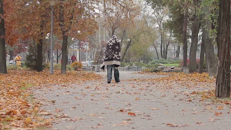 Dziwaczna mężczyzna błąkanina w miasto parku zakrywającym z koc, umysłowo - chora osoba