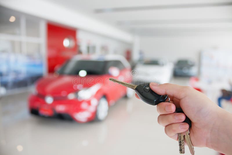Dé llevar a cabo llaves del coche en la nueva sala de exposición del coche imagen de archivo Dé llevar a cabo llaves del coche en la nueva sala de exposición del coche imagen de archivo