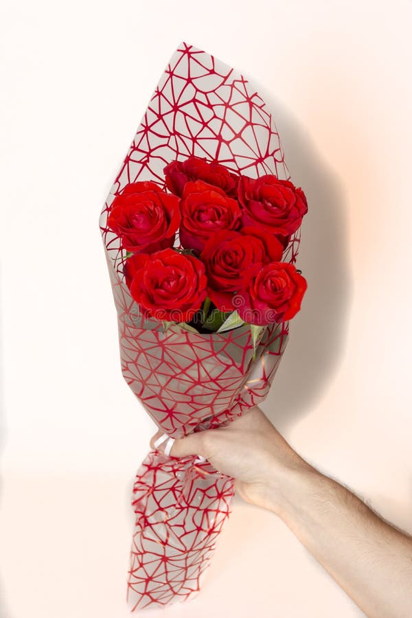Dé sostener el ramo de rosas rojas sobre el fondo blanco fotos de archivo libres de regalías Dé sostener el ramo de rosas rojas sobre el fondo blanco fotos de archivo libres de regalías