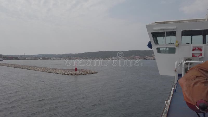 Débordements de ferry sur la mer calme vers l'entrée du port de l'île de San Pietro