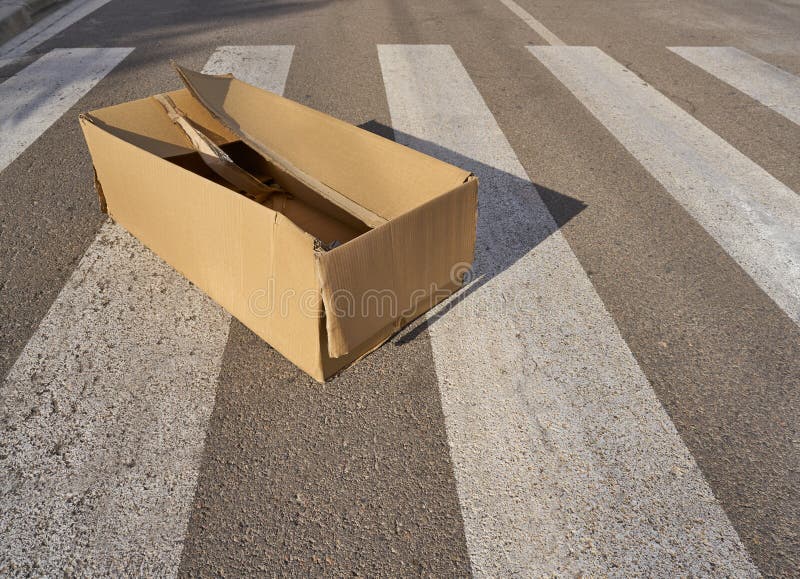 Cardboard box trash in the crosswalk recycling concept. Cardboard box trash in the crosswalk recycling concept