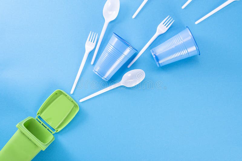 Déchets ménagers sur fond bleu et contenant des ordures Le concept de tri du plastique, du polyéthylène, du carton, du papier, photographie stock Déchets ménagers sur fond bleu et contenant des ordures Le concept de tri du plastique, du polyéthylène, du carton, du papier, photographie stock