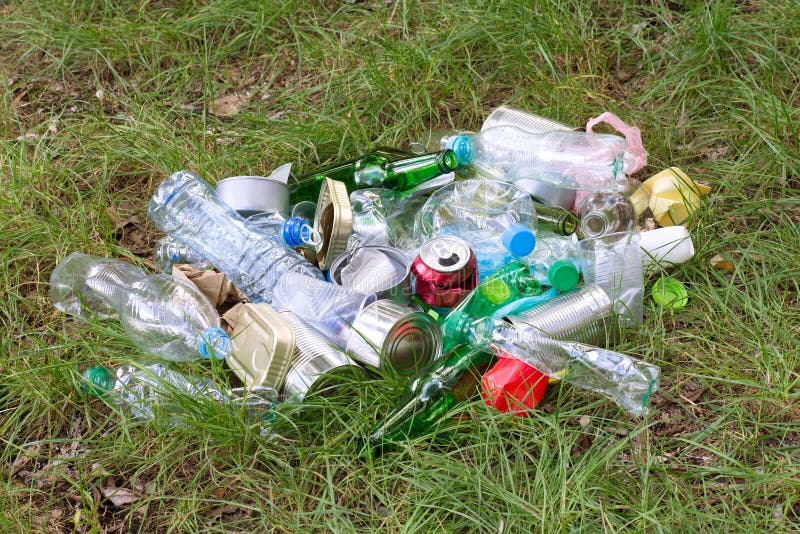 Déchets tels que les bouteilles en plastique et en verre, les boîtes, les boîtes et les morceaux de papier sur l'herbe photos libres de droits Déchets tels que les bouteilles en plastique et en verre, les boîtes, les boîtes et les morceaux de papier sur l'herbe photos libres de droits