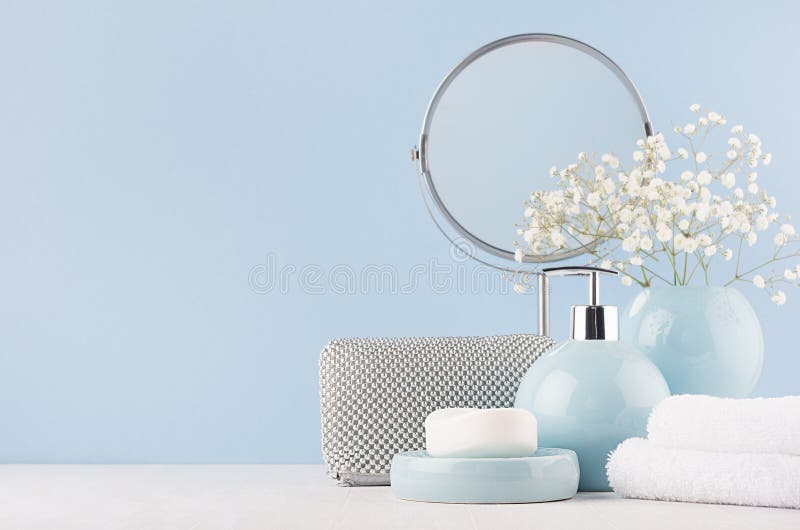 Décor de salle de bains pour la femelle dans la couleur bleue douce légère - entourez le miroir, le sac cosmétique argenté, les f photographie stock Décor de salle de bains pour la femelle dans la couleur bleue douce légère - entourez le miroir, le sac cosmétique argenté, les f photographie stock