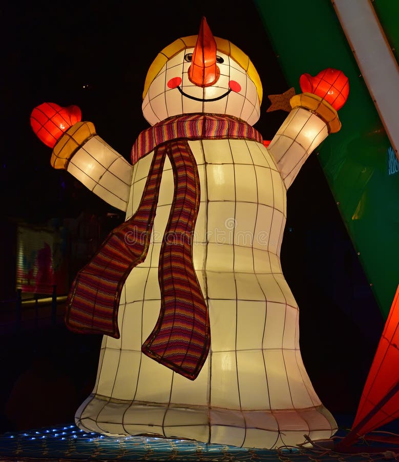 Décoration légère colorée de bonhomme de neige riant semblant heureuse avec la longue écharpe photographie stock libre de droits