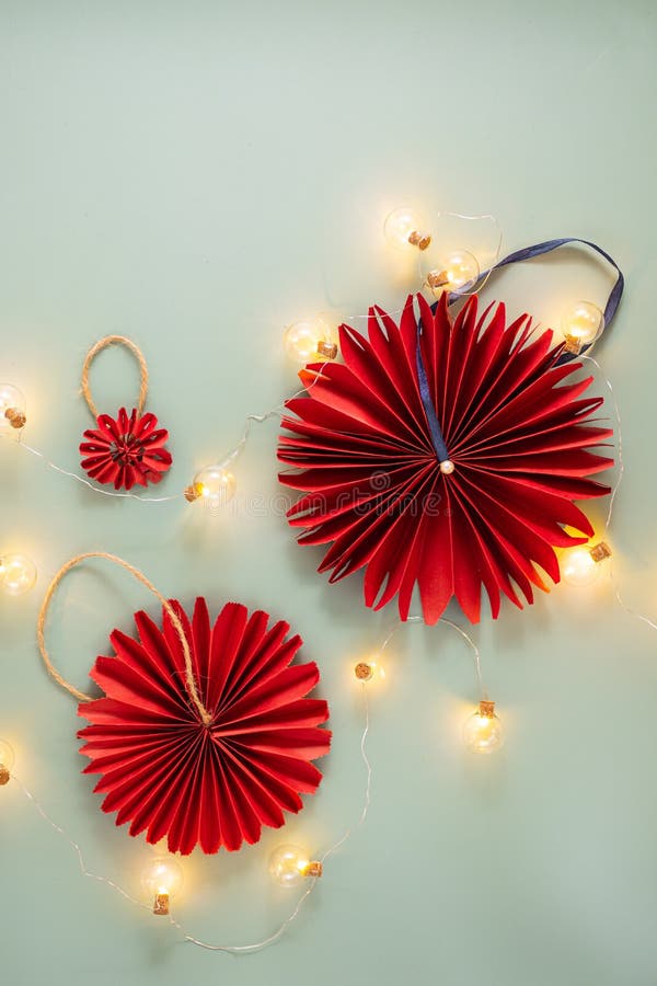 Décorations de noël faites à la main à partir de papier d'artisanat bordeaux dans un style rétro sur fond vert uni. joyeux concept photographie stock libre de droits
