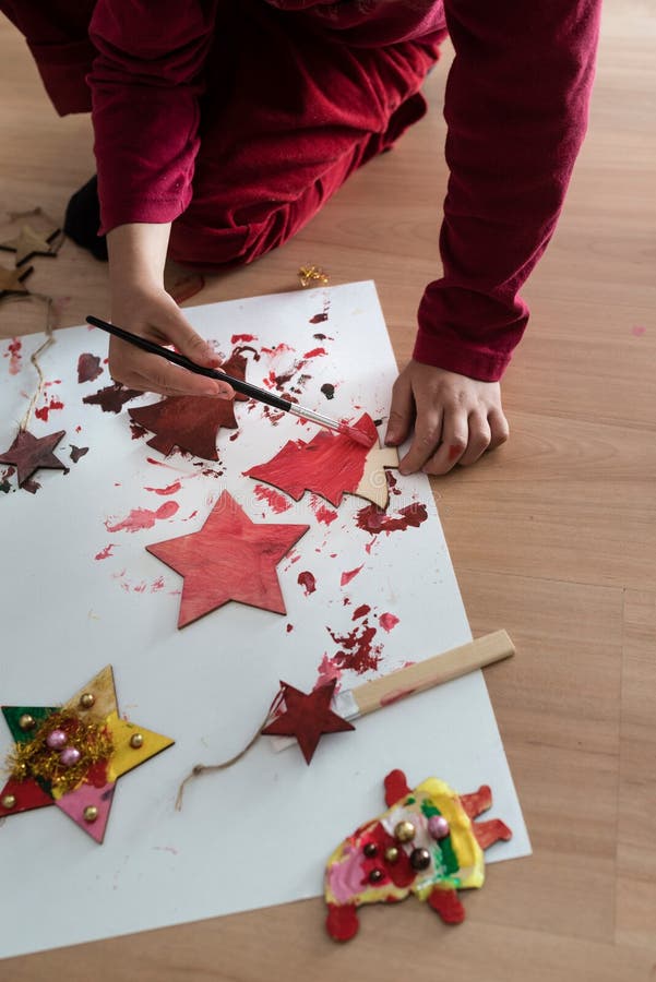 Décorations de Noël de peinture d'enfant en bas âge se mettant à genoux vers le bas sur images libres de droits