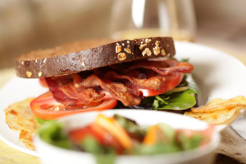 Horizontal shot of a delicious BLT served with salad and a glass of apple juice. Horizontal shot of a delicious BLT served with salad and a glass of apple juice