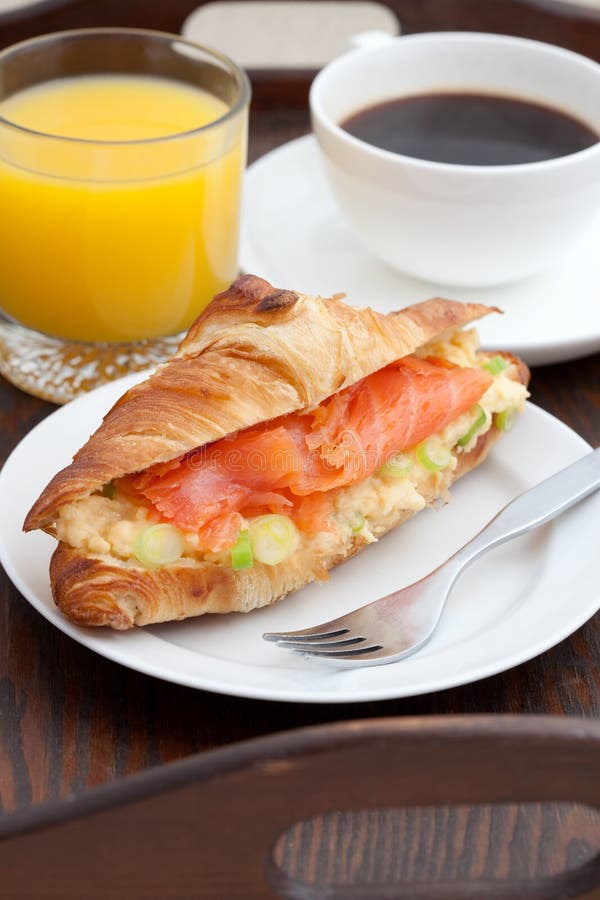 Delicious breakfast of croissant, smoked salmon, coffee and orange juice. Delicious breakfast of croissant, smoked salmon, coffee and orange juice