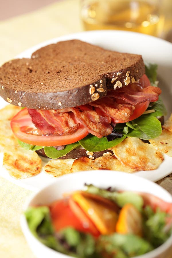 Delicious BLT served with salad and a glass of apple juice. Delicious BLT served with salad and a glass of apple juice