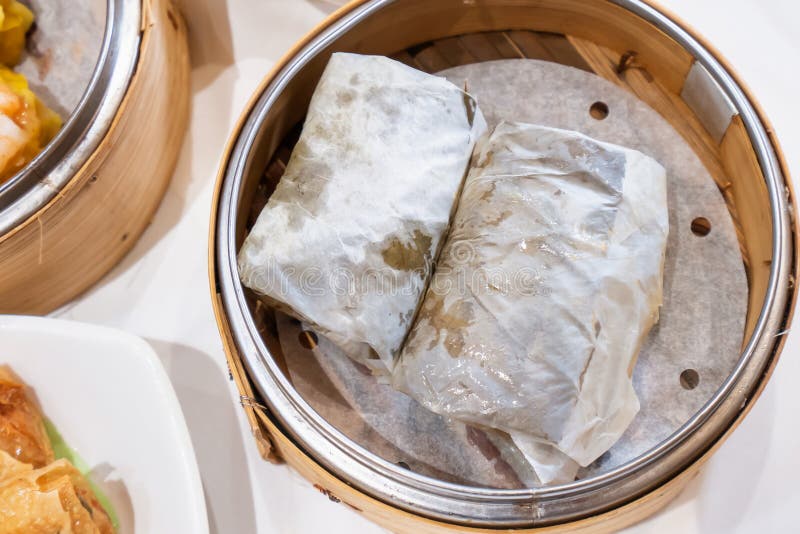 Délicieux Lo Mai Gai dim sum, riz glutineux frais à la vapeur et roulé au poulet enveloppé de feuilles de lotus dans du bambou à photographie stock libre de droits Délicieux Lo Mai Gai dim sum, riz glutineux frais à la vapeur et roulé au poulet enveloppé de feuilles de lotus dans du bambou à photographie stock libre de droits