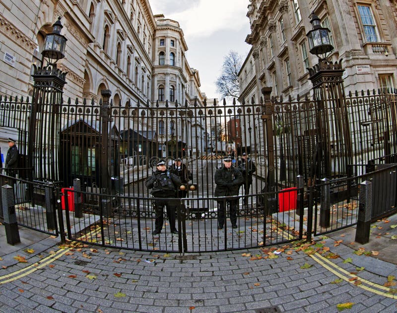 The entrance from Whitehall into Downing Street, the home of the Prime Minister of the UK. Shot with a fisheye lens to show the whole scene including the intensive overt security that surrounds a modern democracy. The entrance from Whitehall into Downing Street, the home of the Prime Minister of the UK. Shot with a fisheye lens to show the whole scene including the intensive overt security that surrounds a modern democracy.