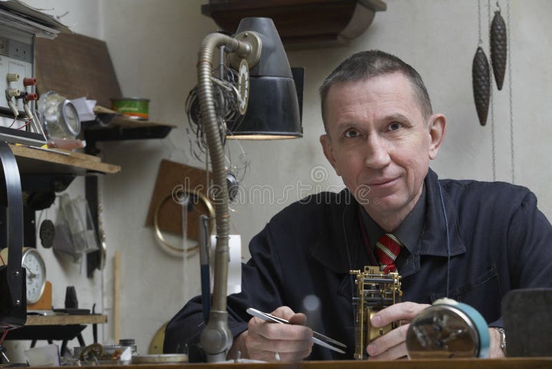 Dépanneur Working On Clock dans l'atelier photo stock