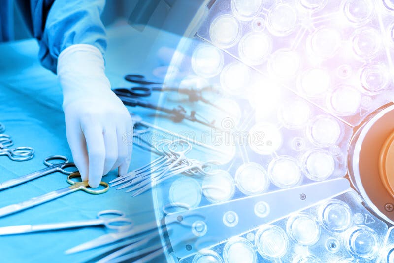 Détaillez le tir des instruments steralized de chirurgie avec une main saisissant un outil et une salle en fonction de lampes chi image stock Détaillez le tir des instruments steralized de chirurgie avec une main saisissant un outil et une salle en fonction de lampes chi image stock