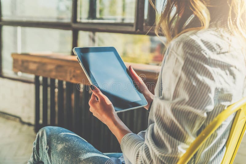 Día asoleado Primer de la tableta en las manos de la mujer joven que se sientan en sitio en silla Muchacha del inconformista que fotografía de archivo