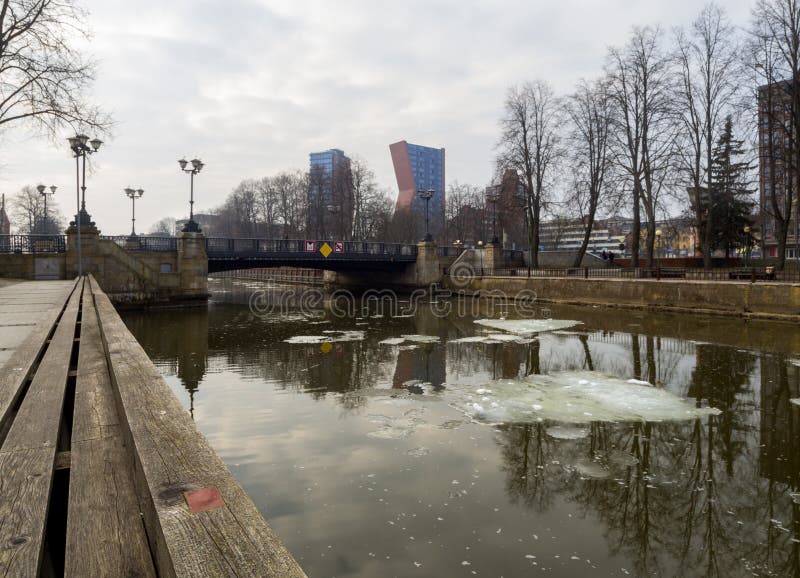 Día de invierno nublado en un río con las masas de hielo flotante de hielo flotantes que pasan por alto los edificios altos y el fotos de archivo libres de regalías Día de invierno nublado en un río con las masas de hielo flotante de hielo flotantes que pasan por alto los edificios altos y el fotos de archivo libres de regalías