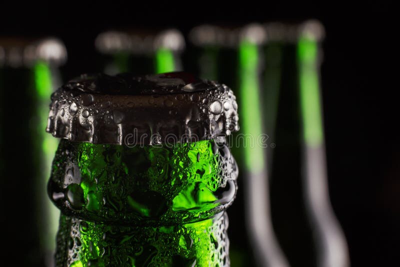 Día del ` s de St Patrick Cerveza verde fresca en la botella con descensos del condensado en un fondo negro Concepto: Pub, día c imagen de archivo libre de regalías Día del ` s de St Patrick Cerveza verde fresca en la botella con descensos del condensado en un fondo negro Concepto: Pub, día c imagen de archivo libre de regalías