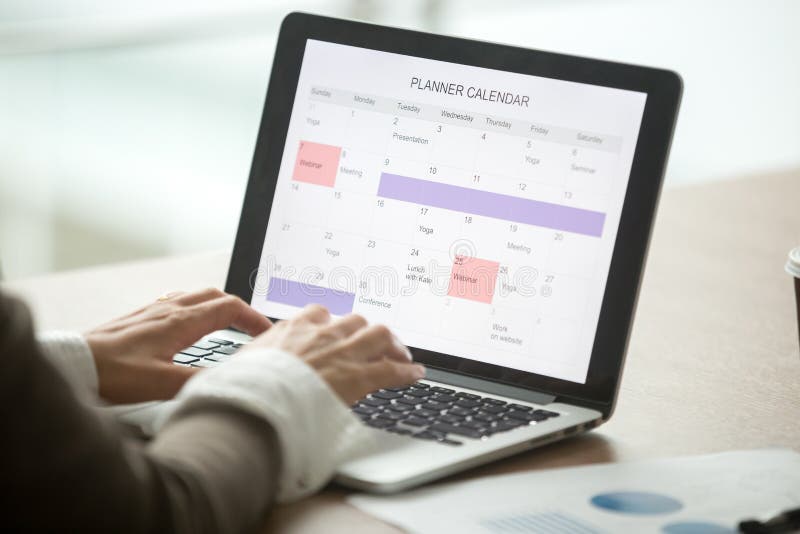 Día usando calendario digital en el ordenador portátil, clo del planeamiento de la empresaria