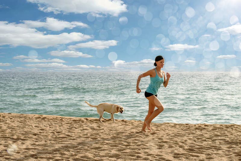 Dünnes sportliches Mädchen, das mit einem Hund auf dem Strand in den sunlights läuft. Tätigkeiten der Freizeit im Freien, die das