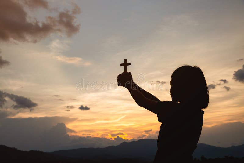 Hand of a girl holding a cross at sunrise, Eucharist Therapy Bless God Helping Repent Catholic Easter Lent Mind Pray. Prayer to God Christian Religion concept background. Hand of a girl holding a cross at sunrise, Eucharist Therapy Bless God Helping Repent Catholic Easter Lent Mind Pray. Prayer to God Christian Religion concept background.