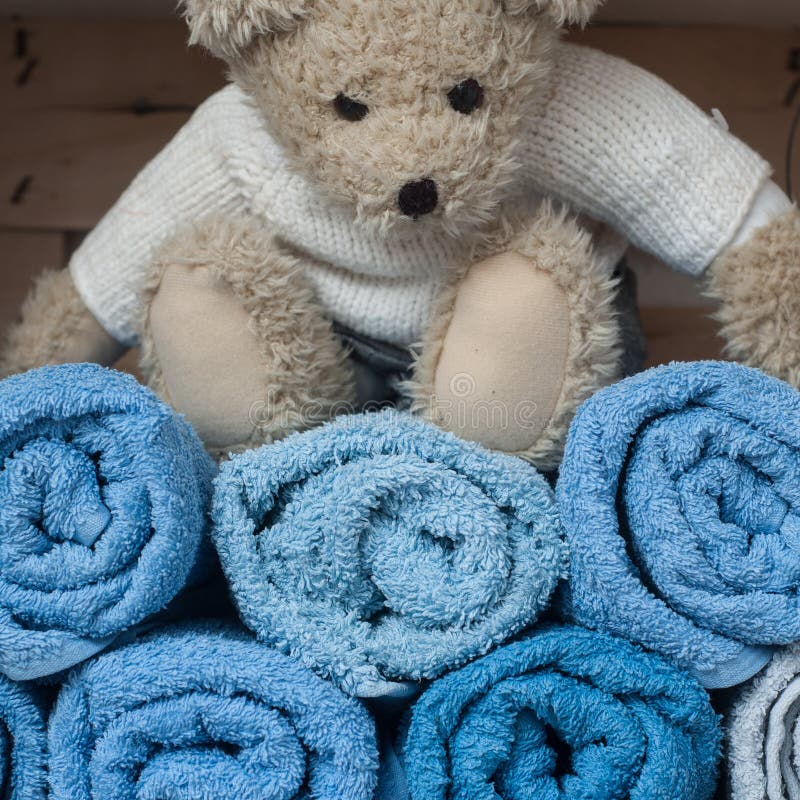Teddy Bear on Rolled Blue Bath Towels in Bathroom Obraz Stock Obraz