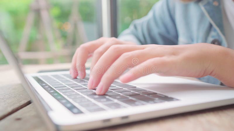 Mujer asiática autónoma trabajando, realizando proyectos y enviando correos electrónicos en un portátil u ordenador mientras está almacen de video