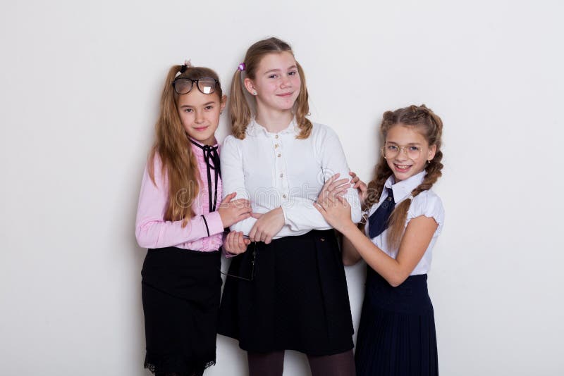 Three girls in glasses at the Blackboard in a class lesson. Three girls girlfriends St Trinian`s school`s lesson in glasses