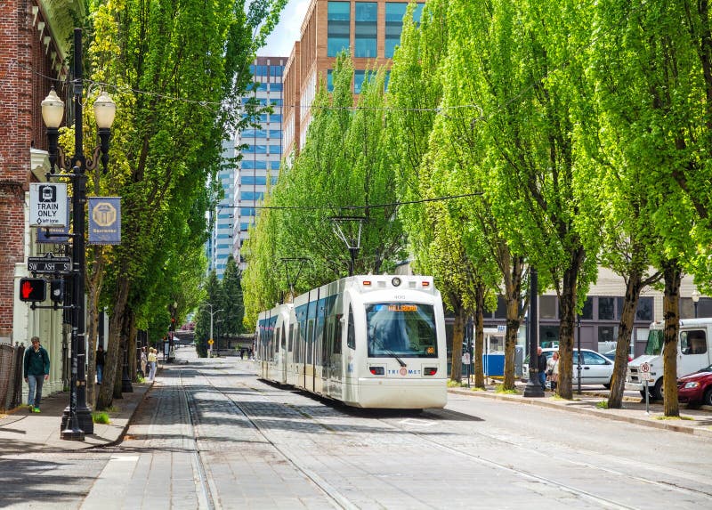 PORTLAND - MAY 4: Light train of the Portland Streetcar system on May 4, 2014 in Portland, Oregon. The Portland Streetcar system opened in 2001 and serves areas surrounding downtown Portland. PORTLAND - MAY 4: Light train of the Portland Streetcar system on May 4, 2014 in Portland, Oregon. The Portland Streetcar system opened in 2001 and serves areas surrounding downtown Portland.