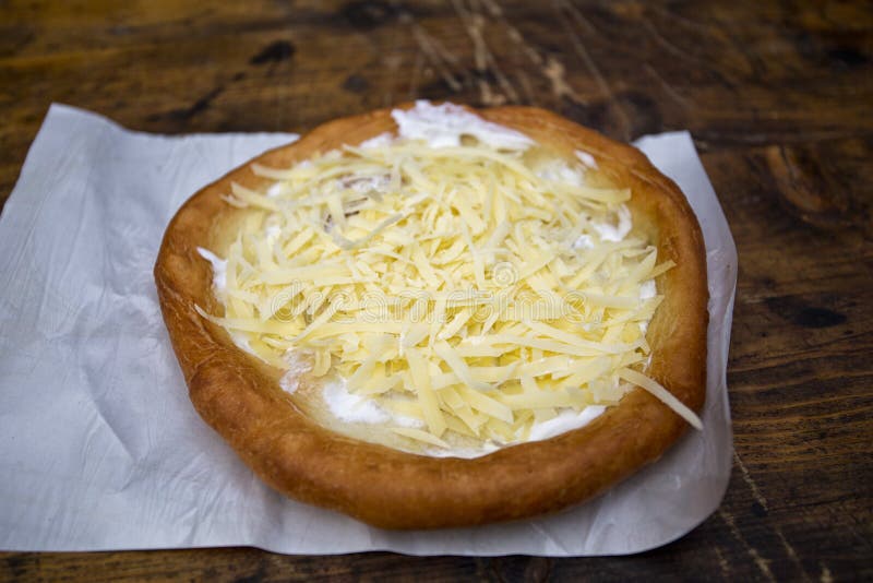 Langos, traditional Hungarian food, fried yeast dough eaten with cheese and sour cream and garlic.