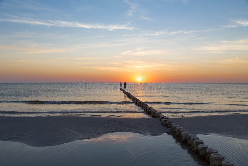 Adolescenti che camminano su uno sperone roccioso al tramonto immagini stock