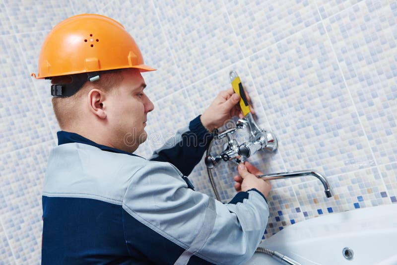 E arbetare som installerar blandareklappet arkivfoton E arbetare som installerar blandareklappet arkivfoton