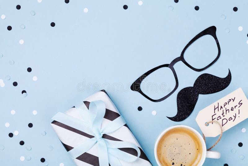 Holiday breakfast on Happy Fathers Day with coffee, gift box and funny glasses and moustache on table top view. Flat lay style. Holiday breakfast on Happy Fathers Day with coffee, gift box and funny glasses and moustache on table top view. Flat lay style