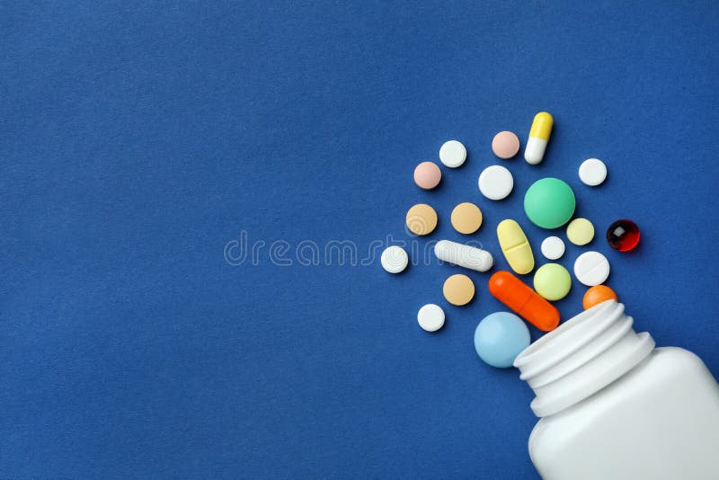 Bottle with different pills on color background, flat lay. E Espacio para el texto