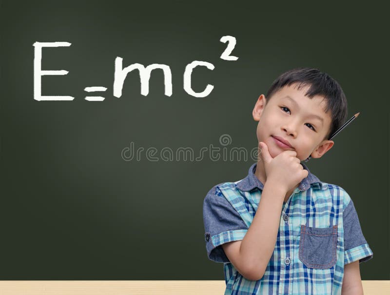 学生在黑板旁，写着e=mc2 免版税库存图片
