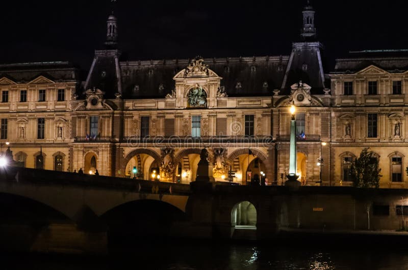 E O museu Paris do Louvre e ponte Pont du Carrossel sobre o rio Seine na noite imagens de stock royalty free E O museu Paris do Louvre e ponte Pont du Carrossel sobre o rio Seine na noite imagens de stock royalty free