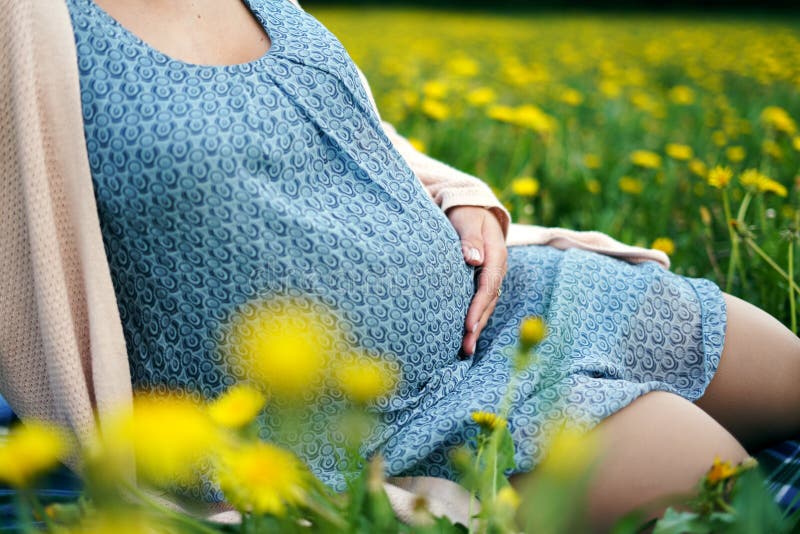 E o Парк ожидающего женского касающего tummy на открытом воздухе весной, стоковые фото E o Парк ожидающего женского касающего tummy на открытом воздухе весной, стоковые фото