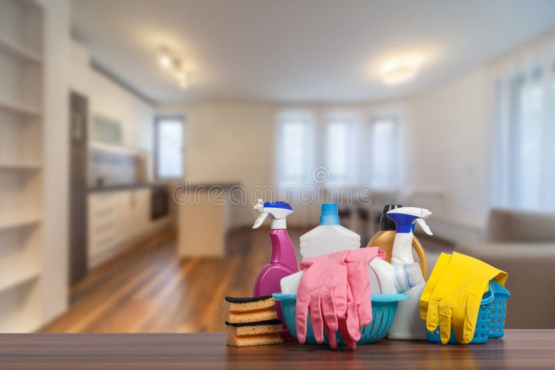 Home cleaning service concept with supplies. Cleaning supplies in front of livingroom. Home cleaning service concept with supplies. Cleaning supplies in front of livingroom.