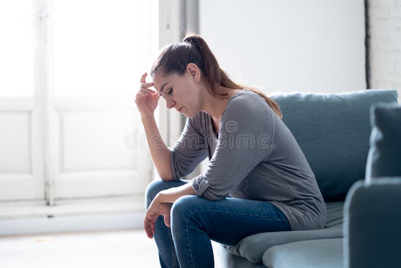 Young attractive latin woman lying at home living room couch feeling sad tired and worried suffering Depression in Mental health, Problems Emotional pain and Broken heart concept