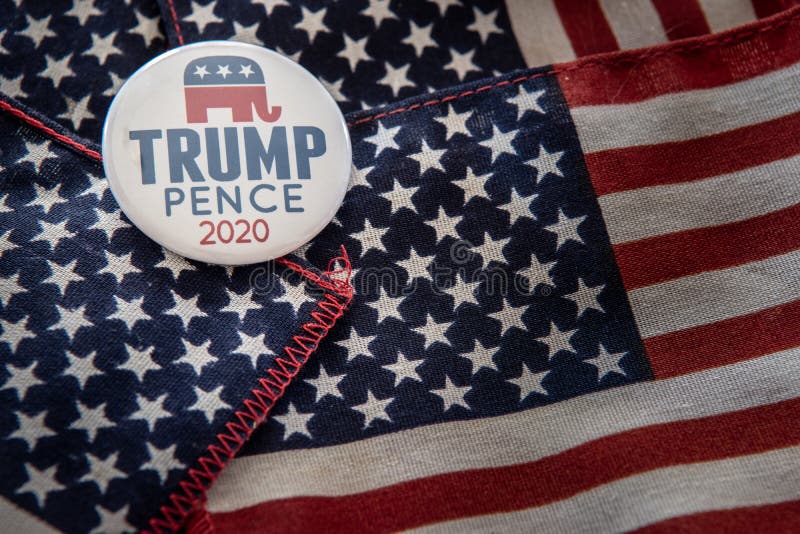 Selinsgrove, PA - April 11, 2019 : Trump-Pence 2020 pin badge shot over United States of America flag in natural light- image. Selinsgrove, PA - April 11, 2019 : Trump-Pence 2020 pin badge shot over United States of America flag in natural light- image