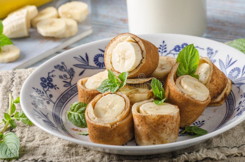 Cinnamon banana pancakes. Delish sweet dessert with mint and sugar, fresh bio banana and milk from farm