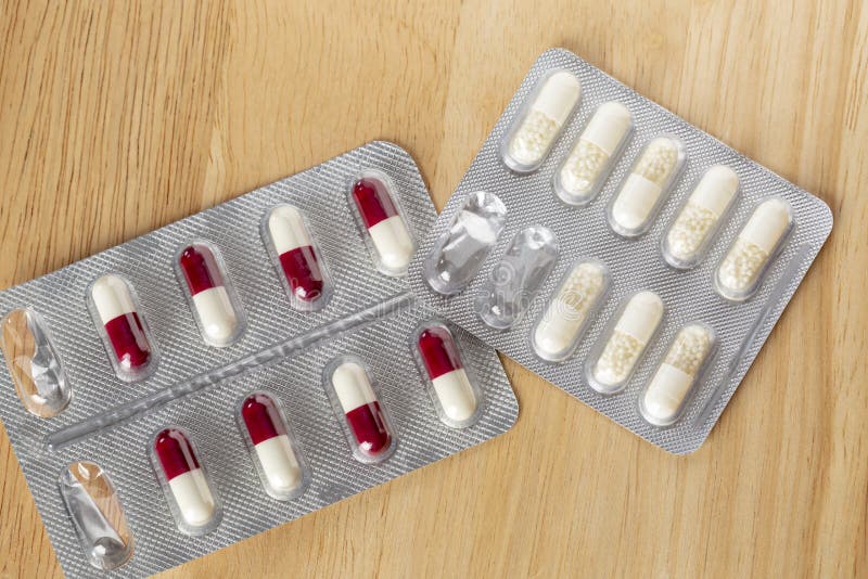 Different pill bottle and white pills on wooden table. Different pill bottle and white pills on wooden table