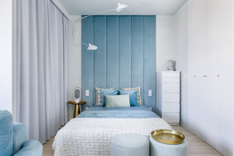 Modern blue and gray bedroom with upholstered wall panels and double bed. Modern blue and gray bedroom with upholstered wall panels and double bed