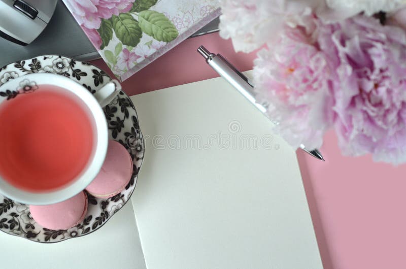 Elegant styled feminine desktop with pink peonies, fruit tea or black coffee and stylish stationery. Elegant styled feminine desktop with pink peonies, fruit tea or black coffee and stylish stationery