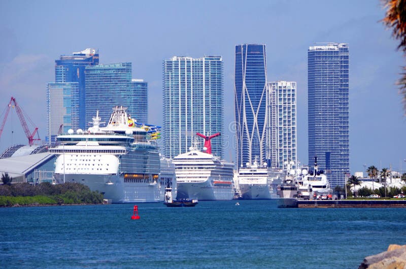 Caribbean bound cruise ships taking on passengers at the Port of Miami,Florida.In the background the Miamitall building skyline. Caribbean bound cruise ships taking on passengers at the Port of Miami,Florida.In the background the Miamitall building skyline.