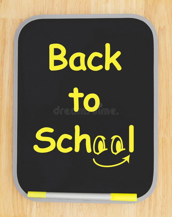 Back to School message on black dry erase board with marker on wood textured wall with copy space for your message