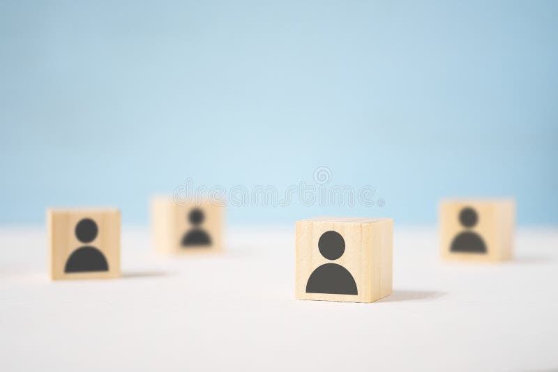 Wooden toy cubes with painted men stand apart from each other. The concept of loneliness in a crowd, disunity, fragmentation