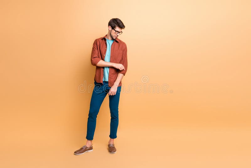 Full length body size view of his he nice attractive fashionable calm, brunette guy fixing sleeves preparing partner meeting isolated over beige color pastel background. Full length body size view of his he nice attractive fashionable calm, brunette guy fixing sleeves preparing partner meeting isolated over beige color pastel background
